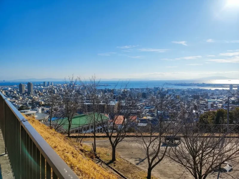 高台から見下ろした曇りの街並みを、AIにより晴天に加工したAI生成画像